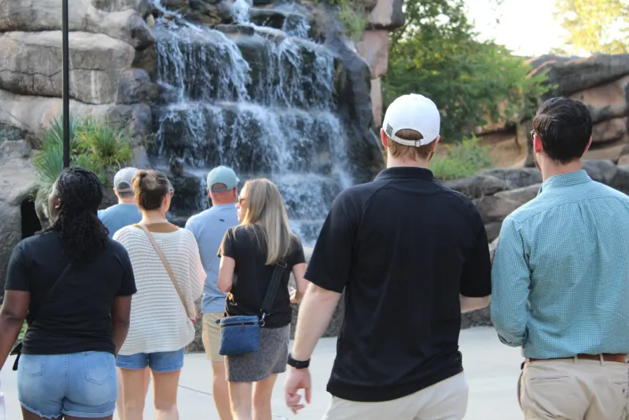 Guests walking past a waterfall at the zoo